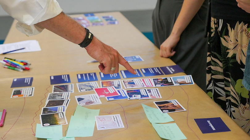 Participants réunis autour d’une table, plaçant des cartes de la Fresque Systémique.